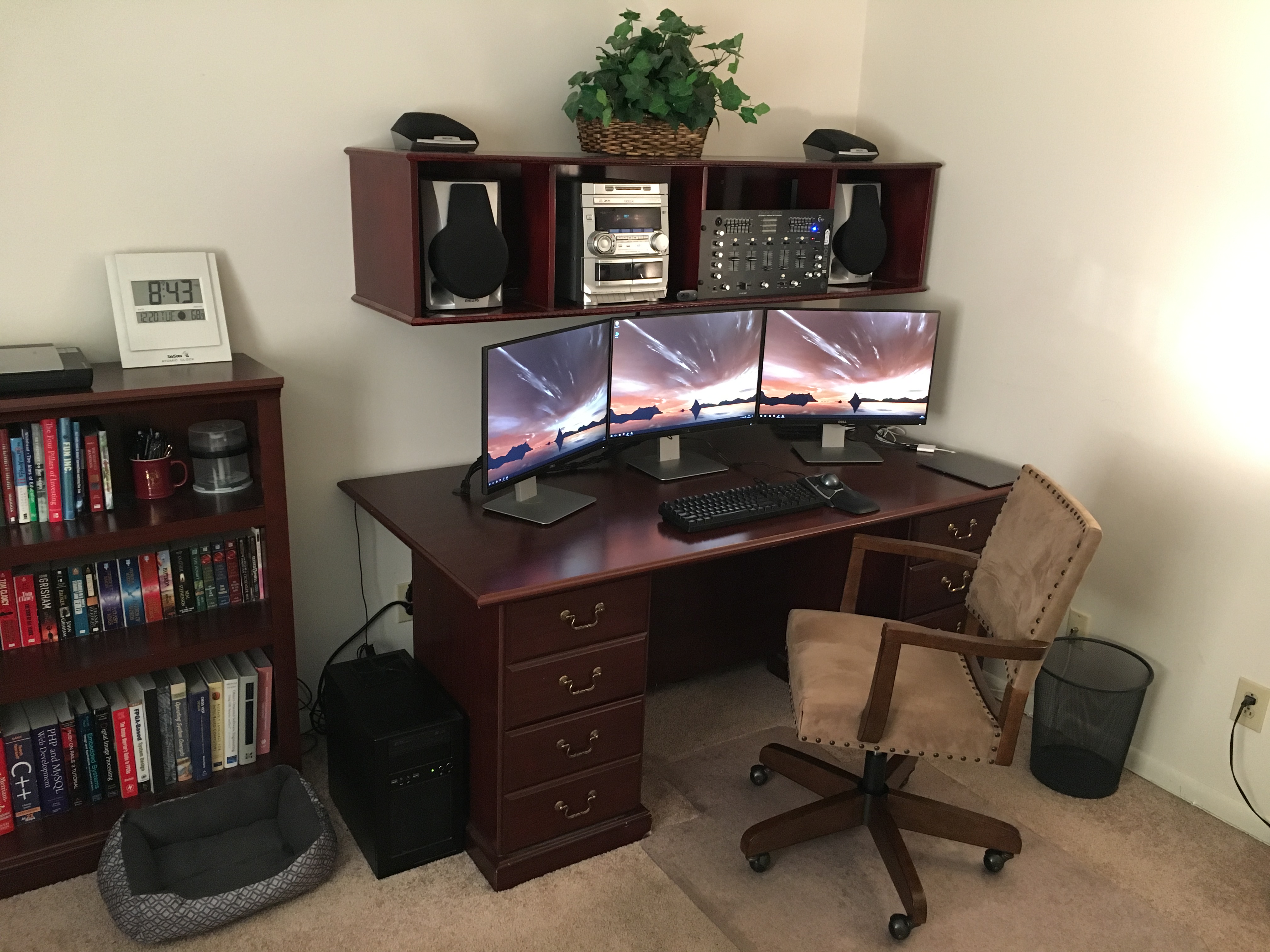 Photo of Paul's desk, showing a desktop with three monitors and a laptop.