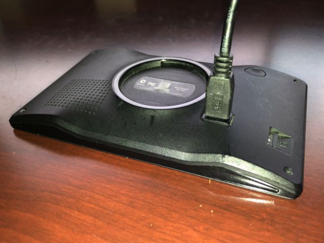 Photo of a Garmin DriveSmart 50 LMT GPS device, with a USB cable plugged into the back of it.