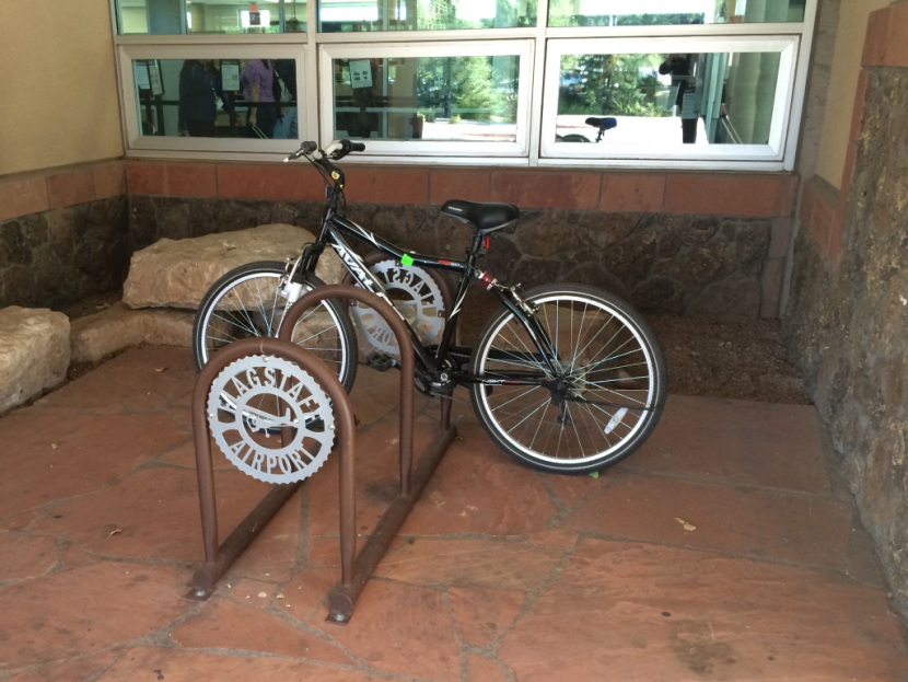 A customized bike rack with a Flagstaff Airport logo.