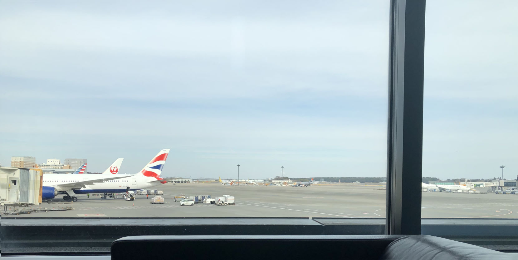 View of jets out the window of an airline lounge.