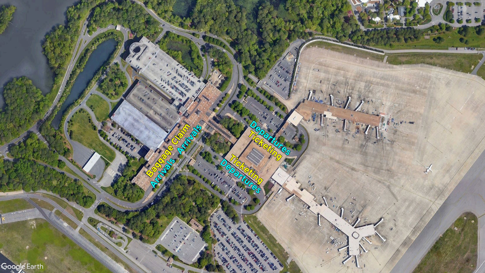 Google Earth imagery of ORF, labeling the departures, ticketing, baggage claim, and arrivals. Departures and ticketing are in one building, while baggage claim and arrivals are in another.