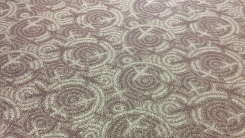 Carpet with a pattern made up of airplane shapes and circles.