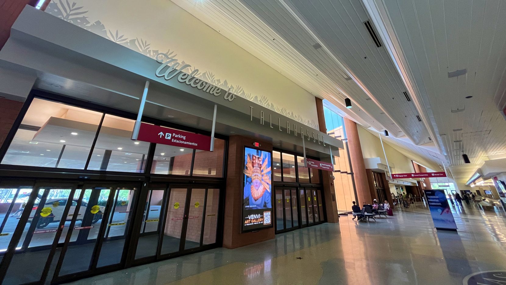 Welcome to Tallahassee sign above the doors in the main lobby of the landside terminal. The ceiling slopes up with a stairstep effect.