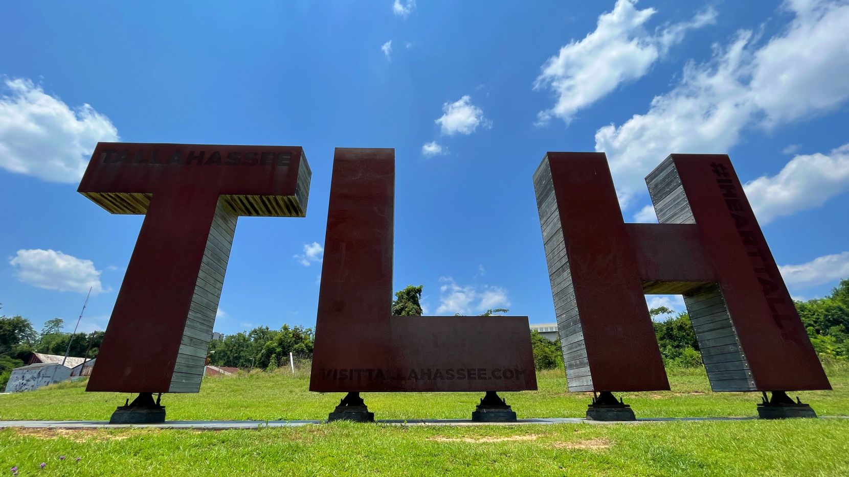 Large sculpture of the letters TLH made out of metal and wood.