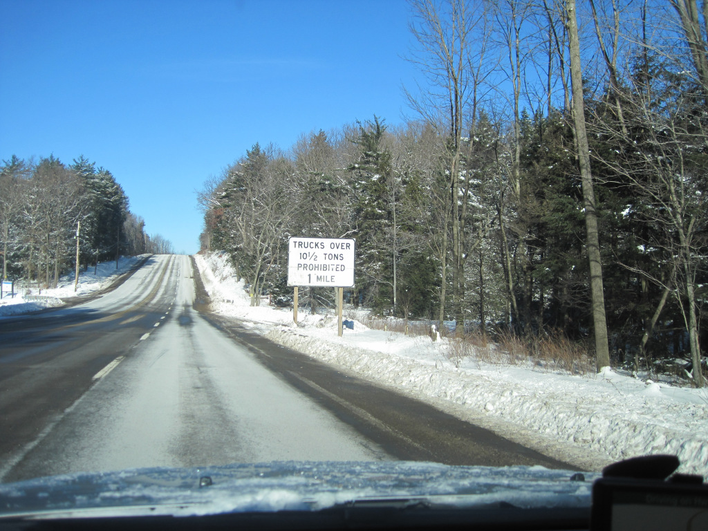 Photo of no trucks sign on the side of the road leading to the hill from the song.