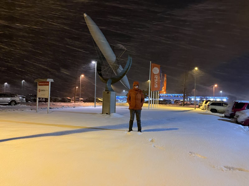 Paul standing in front of Akureyri airport in a snowstorm