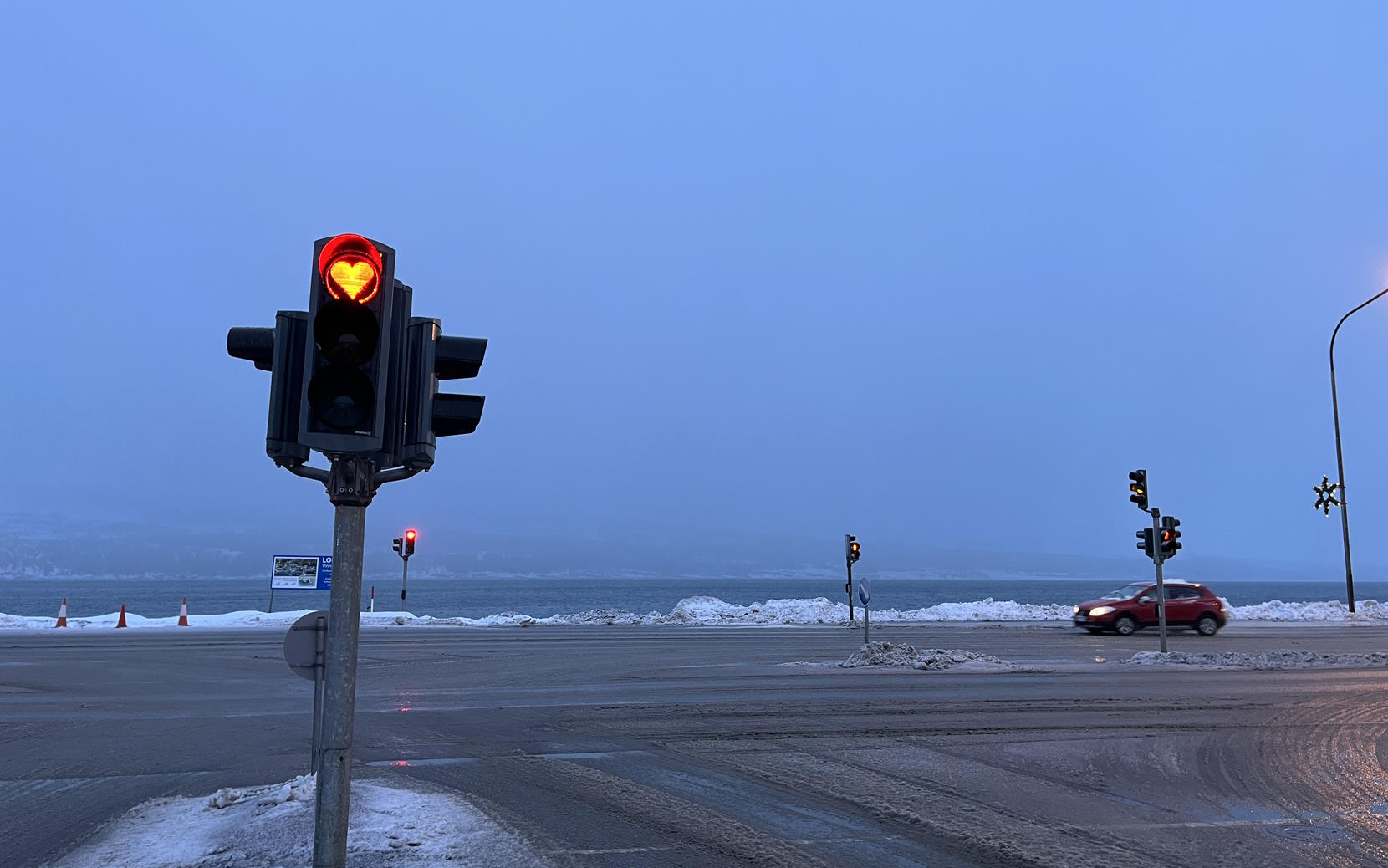 Traffic signals in Akureyri; the red light is in the shape of a heart.