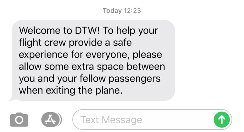 A text message: Welcome to DTW! To help your flight crew provide a safe experience for everyone, please allow some extra space between you and your fellow passengers when exiting the plane.