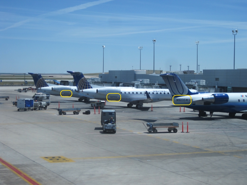 Several airplanes at Denver, with their tail numbers outlined in yellow.