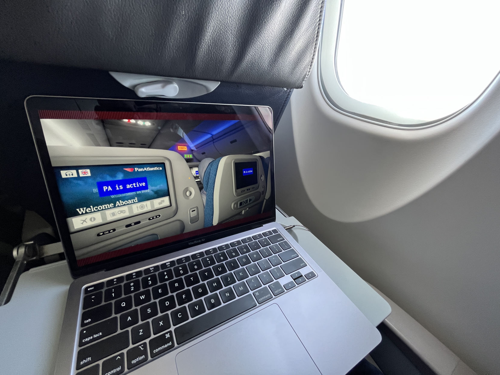 A laptop on an airplane tray table, playing the game Airplane Mode