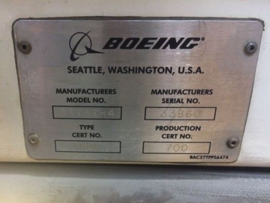 Metal Boeing plaque at the top of an aircraft door frame, showing Manufacturers Serial No. as 33860.